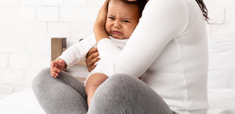 bébé dans les bras de sa maman ayant une migraine