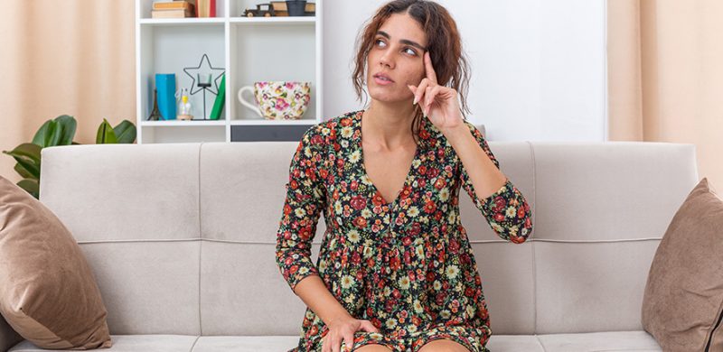 Photographie d'une femme se questionnant sur d'éventuels symptomes de grossesse.